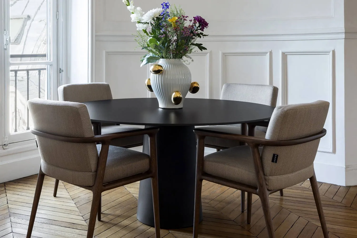 A circular dining table with four chairs showing how many dining room chairs you need.