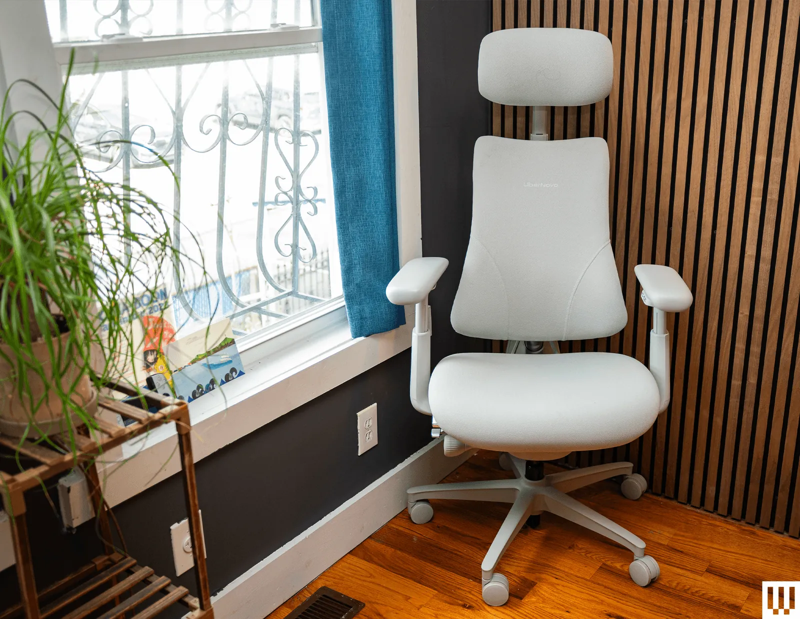 A person sitting in an ergonomic chair with focus on the adjustable lumbar support.
