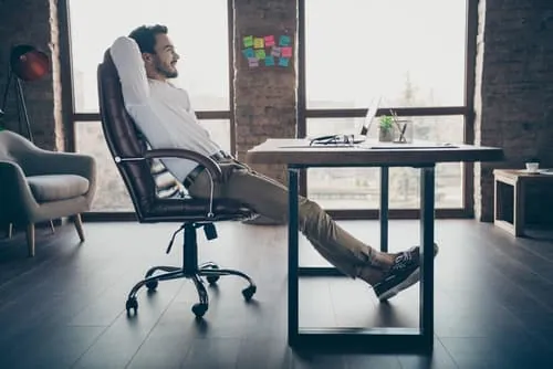 Correct posture and desk clearance when using an ergonomic office chair for work.