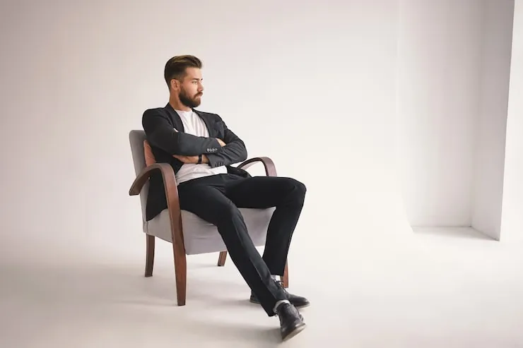 A person demonstrating good posture while sitting on the edge of a chair.