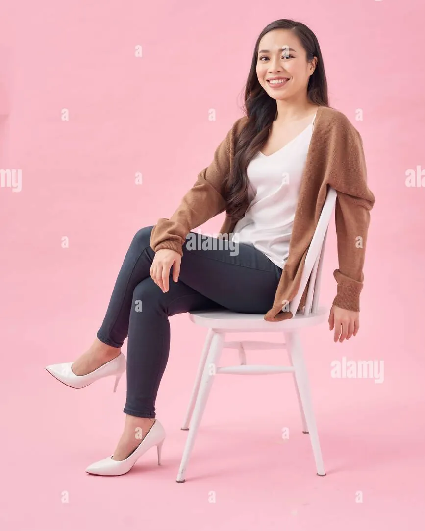 A person holding a coffee cup as a simple prop while sitting down.