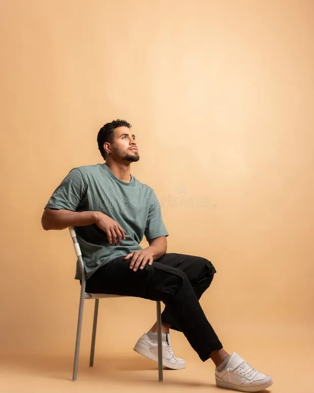 A person sitting comfortably on a chair while focusing on graceful foot placement.