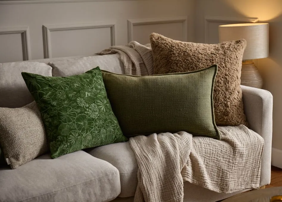 Using a fitted slipcover to update the appearance of a worn brown couch.